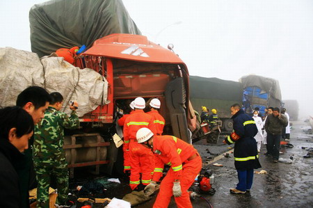 Firefighters and medical staff rescue the victims of a severe pile-up crash believed to have been caused by low visibility in the heavy fog and slippery road surfaces in Jiangxi province on December 28, 2009. [Xinhua]