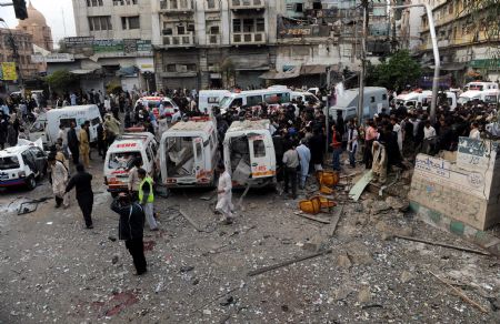 Ambulances gather at the site where a bomb blast struck a major Shiite Muslim procession in Karachi, Pakistan, Monday, Dec. 28, 2009.