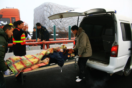 People take the injured into an ambulance at a traffic accident site on the Poyang Lake Bridge in east China's Jiangxi Province, Dec. 28, 2009. (Xinhua Photo)