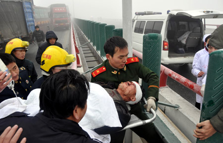 Rescuers transfer the injured at the traffic accident site on the Poyang Lake Bridge in east China's Jiangxi Province, Dec. 28, 2009. (Xinhua Photo)