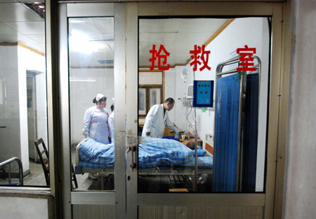 A doctor checks the injured of a traffic accident happened on the Poyang Lake Bridge at the Affiliated Hospital of Jiujiang University in Jiujiang, east China's Jiangxi Province, Dec. 28, 2009. (Xinhua Photo)