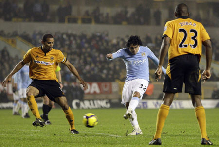 Manchester City's Carlos Tevez (C) scores his second goal against Wolverhampton Wanderers during their English Premier League soccer match at Molineux in Wolverhampton, central England, December 28, 2009. 