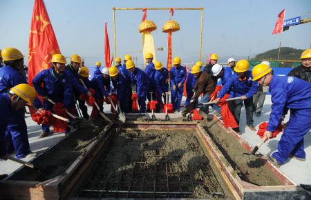 Construction workers pour concrete to a building of the new Beichuan Middle School, in Beichuan county, southwest China