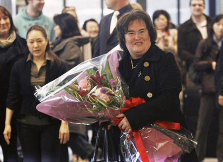 British singer Susan Boyle poses with a bouquet upon her arrival at Narita International Airport, near Tokyo December 29, 2009. Boyle arrived in Japan on Tuesday to make an appearance for a new year eve's programme on Japanese television.