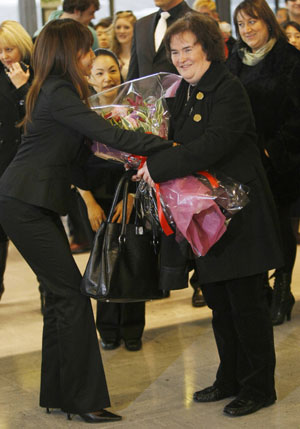 British singer Susan Boyle (R) receives a bouquet upon her arrival at Narita International Airport, near Tokyo December 29, 2009. Boyle arrived in Japan on Tuesday to make an appearance for a new year eve's programme on Japanese television.