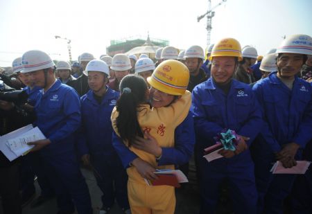 A student of Beichuan Middle School hugs a construction worker after the main buildings of the new Beichuan Middle School completed, in Beichuan county, southwest China's Sichuan Province, Dec. 28, 2009.(Xinhua/Jiang Hongjing)
