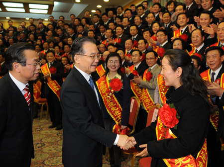 Chinese Premier Wen Jiabao (C, front), also a member of the Standing Committee of the Political Bureau of the Central Committee of the Communist Party of China, shakes hands with one of participants of the National Audit Work Conference and the Commendatory Convention for Outstanding Audit Units and Auditors, at the Great Hall of the People in Beijing, Dec. 28, 2009. 