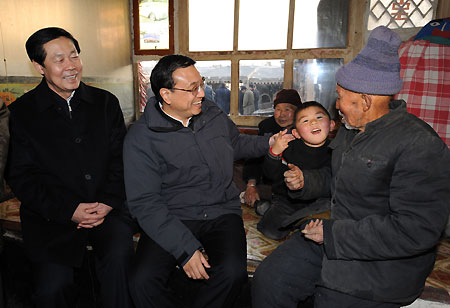 Chinese Vice Premier Li Keqiang (L2) talks with 83-year-old Meng Pin and his family in Yingfanggou Village of Datong, north China's Shanxi Province, Dec. 27, 2009. Li Keqiang made an inspection tour in Shanxi from Dec. 27 to 28. 