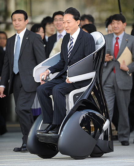 Japan&apos;s Prime Minister Yukio Hatoyama rides Toyota&apos;s personal mobility i-REAL during a photo session after a news conference to announce the government&apos;s new growth strategy, at his official residence in Tokyo December 30, 2009. [Chinanew.com.cn] 