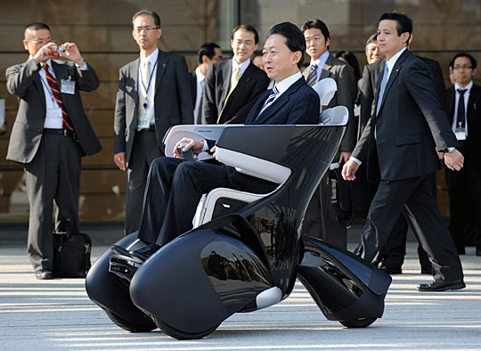 Japan&apos;s Prime Minister Yukio Hatoyama rides Toyota&apos;s personal mobility i-REAL during a photo session after a news conference to announce the government&apos;s new growth strategy, at his official residence in Tokyo December 30, 2009. [Chinanew.com.cn] 