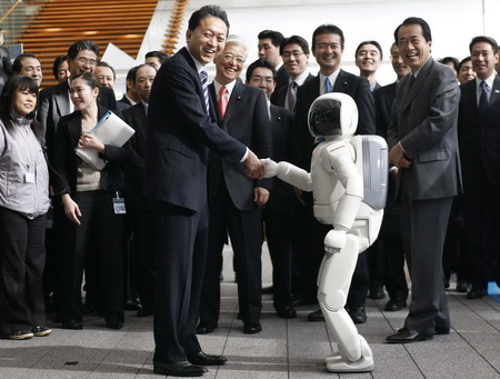 Japan&apos;s Prime Minister Yukio Hatoyama (L) shakes hands with Honda&apos;s humanoid robot Asimo during a photo session after a news conference to announce the government&apos;s new growth strategy, at his official residence in Tokyo December 30, 2009.[China Daily via Agencies]