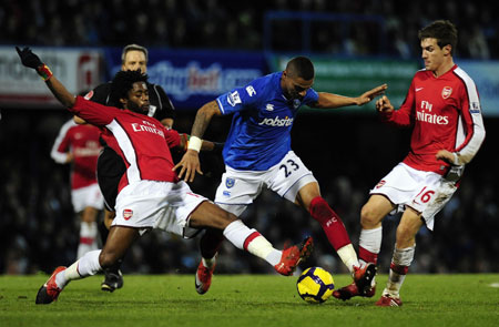 Portsmouth's Kevin-Prince Boateng (C) is challenged by Arsenal's Alex Song (L) and Aaron Ramsey during their English Premier League soccer match at Fratton Park in Portsmouth December 30, 2009. [Xinhua/Reuters]