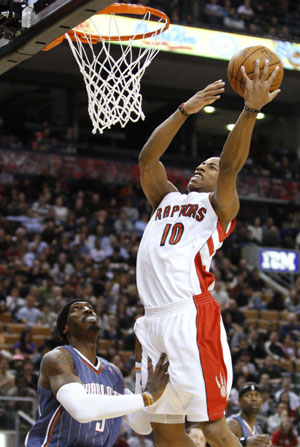 Toronto Raptors DeMar DeRozan goes to the basket against Charlotte Bobcats Gerald Wallace (L) during the first half of their NBA basketball game in Toronto December 30, 2009. Toronto Raptors won 107-103.[Xinhua/Reuters]