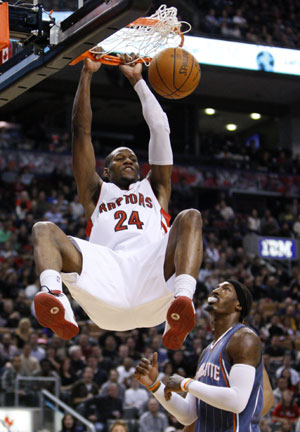 Toronto Raptors Sonny Weems goes up for a slam dunk past Charlotte Bobcats Gerald Wallace (R) during the first half of their NBA basketball game in Toronto December 30, 2009. Toronto Raptors won 107-103.[Xinhua/Reuters]