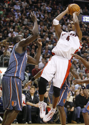 Toronto Raptors Chris Bosh puts up a shot against Charlotte Bobcats DeSagana Diop (L) during the first half of their NBA basketball game in Toronto, December 30, 2009. Toronto Raptors won 107-103.[Xinhua/Reuters] 