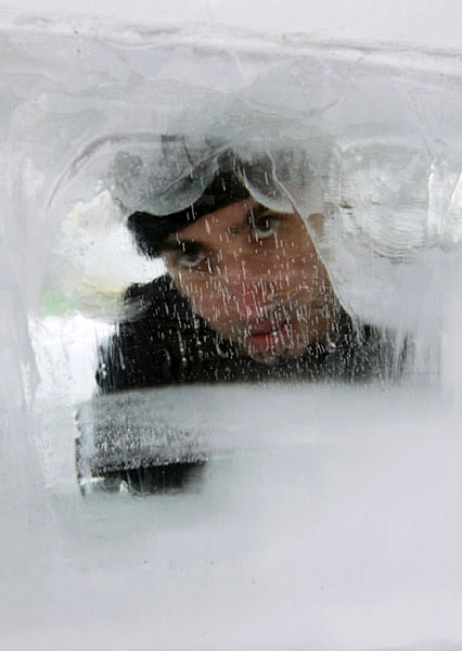 Israeli magician Hezi Dean peers from inside an eight-tonne block of ice at Rabin Square in Tel Aviv December 29, 2009. In an attempt to break David Blaine&apos;s November 2000 record, Dean plans to stay in the ice for 64 hours and emerge at midnight on December 31. [Chinanews.com.cn]