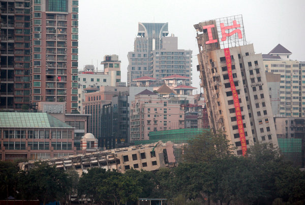 Half of a building leans but fails to fall while the other half collapses after a blasting at the scene of demolition in Liuzhou city, Guangxi Zhuang Autonomous Region on December 30, 2009. The demolition failed due to technical reasons.[CFP]