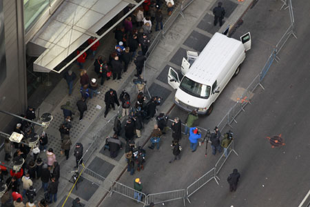 Members of the media and pedestrians inspect a van that has been declared a 