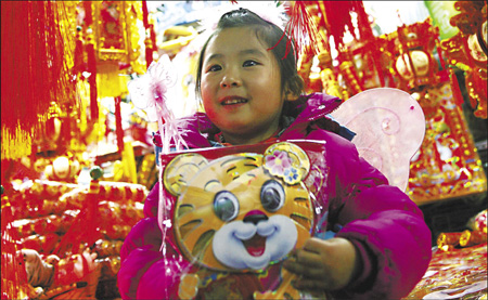 Dou Dou, 5, displays her favorite New Year gift at a shopping center in Beijing yesterday. 