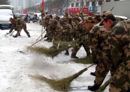  Soldiers of the Armed Police Force clean the snow on the street in Beijing, China, Jan. 3, 2010. Heavy snow hit Beijing on Sunday to close expressways, delay flights and disrupt bus services.