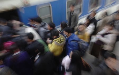 Passengers board the train in Hefei railway station in Hefei, capital of east China's Anhui Province, Jan. 3, 2010. The railway service in Hefei railway station faced passenger peak as the new year holiday came to an end. (Xinhua/Li Jian)