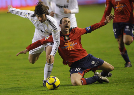 Real Madrid's Esteban Granero (L) fights for the ball against Osasuna's Patxi Punal during their Spanish first division soccer league match at Reyno de Navarra stadium in Pamplona, Jan. 3, 2010. The match ended in a goalless draw. (Xinhua/Reuters Photo) 