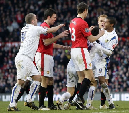 Manchester United's Darron Gibson (2nd L) tussles with Leeds United's Jermaine Beckford (R) and Jonathan Howson (2nd R) during their FA Cup soccer match at Old Trafford in Manchester, northern England Jan. 3, 2010.(Xinhua/Reuters Photo) 