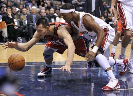 New Jersey Nets center Yi Jianlian and Cleveland Cavaliers guard Daniel Gibson (R) chase a loose ball in the fourth quarter of their NBA basketball game in East Rutherford, New Jersey, January 2, 2010.(Xinhua/Reuters Photo)