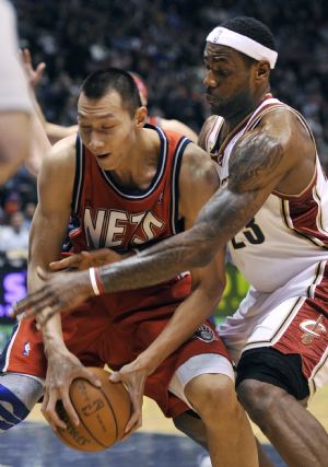 New Jersey Nets forward Yi Jianlian grabs a loose ball in front of Cleveland Cavaliers forward LeBron James (R) in the first quarter of their NBA basketball game in East Rutherford, New Jersey, January 2, 2010.(Xinhua/Reuters Photo)