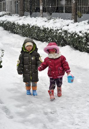 Children play with snow in a community of Shijingshan district, Beijing, China, Jan. 3, 2010. (Xinhua/He Junchang)