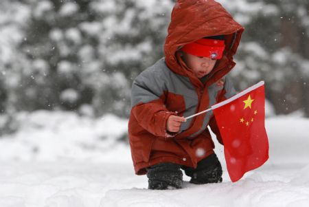 A child plays with snow in a community of Xuanwu district, Beijing, China, Jan. 3, 2010. (Xinhua/Pang Xinglei)