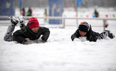 Children play with snow in Qingcheng Park in Hohhot, north China's Inner Mongolia Autonomous Region, Jan. 3, 2010. 