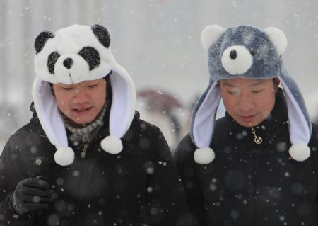 Tourists with cartoon caps enjoy themselves at Tiananmen Square, Beijing, China, Jan. 3, 2010. Heavy snow hit Beijing on Sunday to close expressways, delay flights and disrupt bus services. (Xinhua/Xing Guangli)
