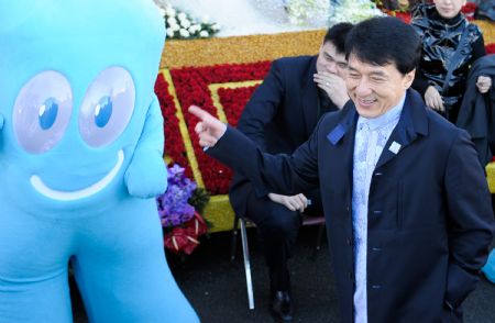 Chinese Hong Kong star Jackie Chan (front) points to a mascot of Shanghai 2010 World Expo during a preview of the Tournament of Roses in Pasadena, California, the United States, on Dec. 31, 2009. 