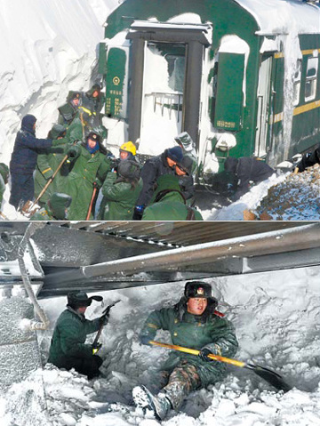 Above and below: Armed police and railway workers remove snow from the track to free a train stranded near Jining in Inner Mongolia yesterday. More than 1,400 passengers were evacuated. Xinhua
