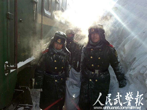 Armed police and railway workers clear the snow covered railway in Shangdu, north China's Inner Mongolia Autonomous Region, January 4, 2010. More than 1,400 passengers were evacuated. [Xinhua]