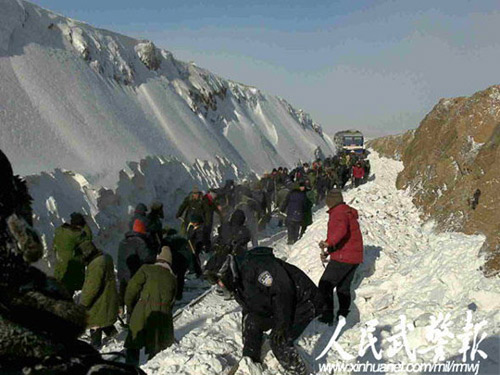 Armed police and railway workers clear the snow covered railway in Shangdu, north China's Inner Mongolia Autonomous Region, January 4, 2010. More than 1,400 passengers were evacuated. [Xinhua]