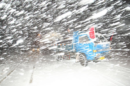 A truck moves on a snow-covered road in the early morning in downtown Yantai, east China's Shandong province, Jan. 4, 2010. The traffic in this costal city became seriously difficult as a snowstorm raided it on Monday. [Photo: Xinhua]