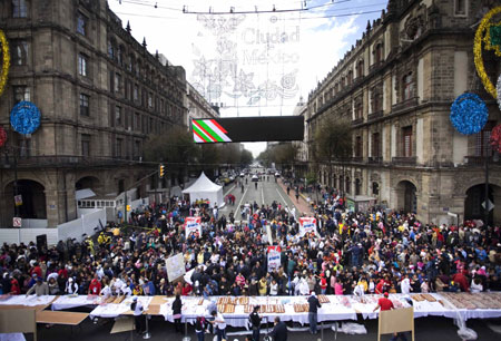 People crowd together while waiting for a piece of the traditional &apos;Rosca de Reyes&apos; in Mexico City, capital of Mexico, on Jan. 3, 2010. The biggest &apos;Rosca de Reyes&apos; of the world, of 720 meters length and 12,000 kg weight, was distributed to 250,000 people at the Zocalo square in Mexico City.[Xinhua]