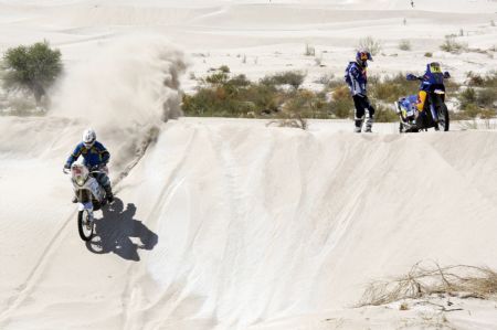 Julian Villarrubia of Spain rides his Yamaha motorcycle past Portugal's Ruben Faria whose motorcycle broke down during the third stage from La Rioja to Fiambala in the 2nd South American edition of the Dakar Rally 2010, January 4, 2010.