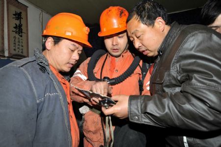 People study rescuing plan at the Lisheng Coal Mine in Tanjiashan Town of Xiangtan County, central-south China's Hunan Province, Jan. 5, 2010. Twenty-seven miners were trapped after a fire happened inside the coal mine on Jan. 5. (Xinhua/Long Hongtao)