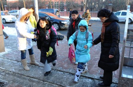  Teachers welcome children in front of a school in Tianjin, north China, on Jan. 5, 2010. Primary and middle schools in the city resumed classes Tuesday after a one-day break due to the heavy snowfall. (Xinhua