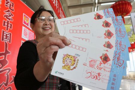 A woman shows a postcard with the stamp and seal marking the 2010 year of tiger in Tianjin, north China, Jan. 5, 2010.