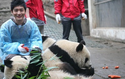 Actor Huang Xiaoming shares a light moment with giant pandas in Ya'an, Sichuan Province on January 5, 2010.