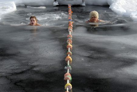 Enthusiasts participate in a winter swimming competition in Vladivostok January 5, 2010. Russian ice swimmers, known as &apos;walruses&apos;, believe that their hobby helps to build up resistance to many illnesses and is crucial for surviving the long winter. [Xinhua/Reuters]