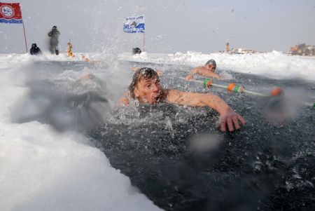 Enthusiasts participate in a winter swimming competition in Vladivostok January 5, 2010. Russian ice swimmers, known as &apos;walruses&apos;, believe that their hobby helps to build up resistance to many illnesses and is crucial for surviving the long winter. [Xinhua/Reuters]