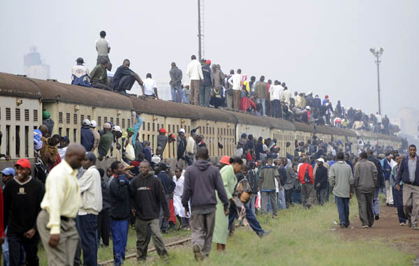 Passengers ride atop overloaded carriages of a commuter train in Kenya&apos;s capital Nairobi, January 5, 2009. Public transport in Kenya&apos;s main cities was paralysed for the second day following a strike by matatu (minibus) drivers and conductors on allegations of extortion and corruption by police.[Xinhua/AFP] 