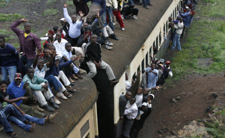 Passengers ride atop overloaded carriages of a commuter train in Kenya&apos;s capital Nairobi, January 5, 2009. Public transport in Kenya&apos;s main cities was paralysed for the second day following a strike by matatu (minibus) drivers and conductors on allegations of extortion and corruption by police. Officials of the drivers and conductors association and the Matatu Welfare Association said the industrial action over harassment by the police would continue unabated. [Xinhua/Reuters] 