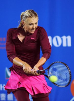 Team Russia's Maria Sharapova returns the ball during the first round match of the Hong Kong Tennis Classic 2010 against China's Zheng Jie of Team Asia Pacific in Hong Kong of south China on Jan. 6, 2010. 