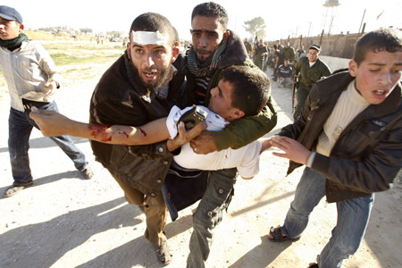 A wounded Palestinians is carried away during a gunbattle near the border between Egypt and the Gaza Strip January 6, 2010. 